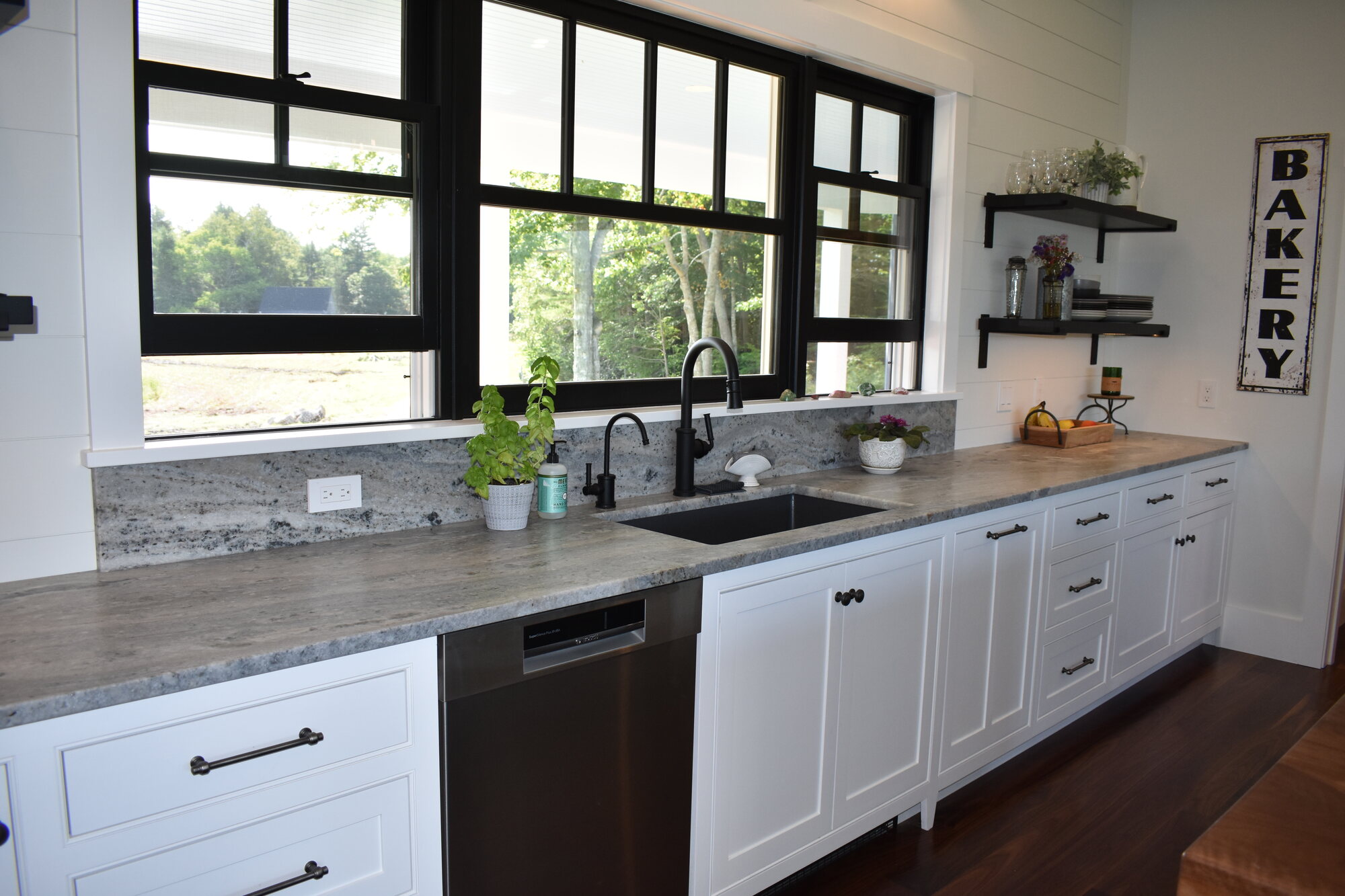Kitchen sink wall with black windows and open shelving