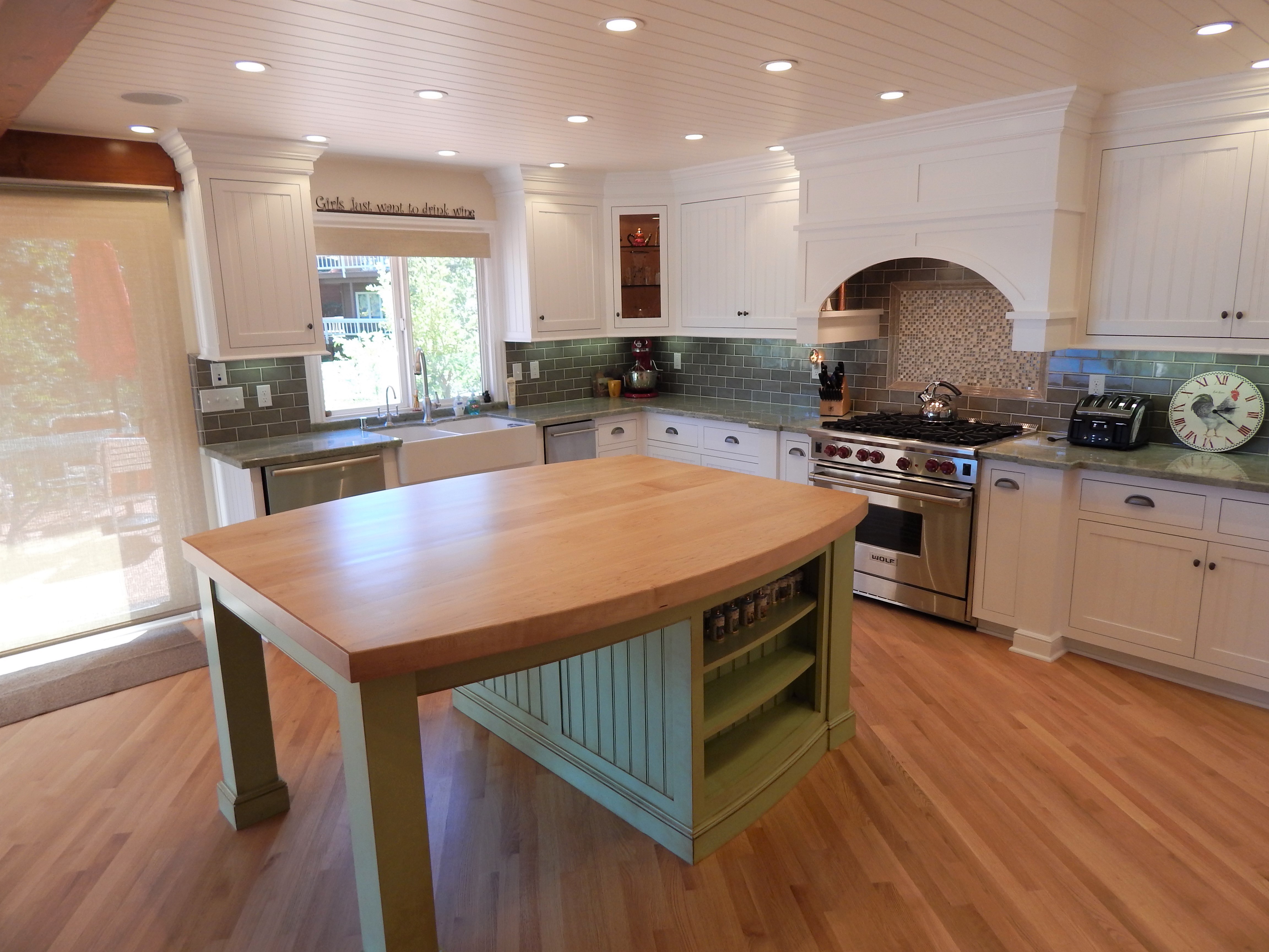 Painted kitchen with green island and tile backsplash