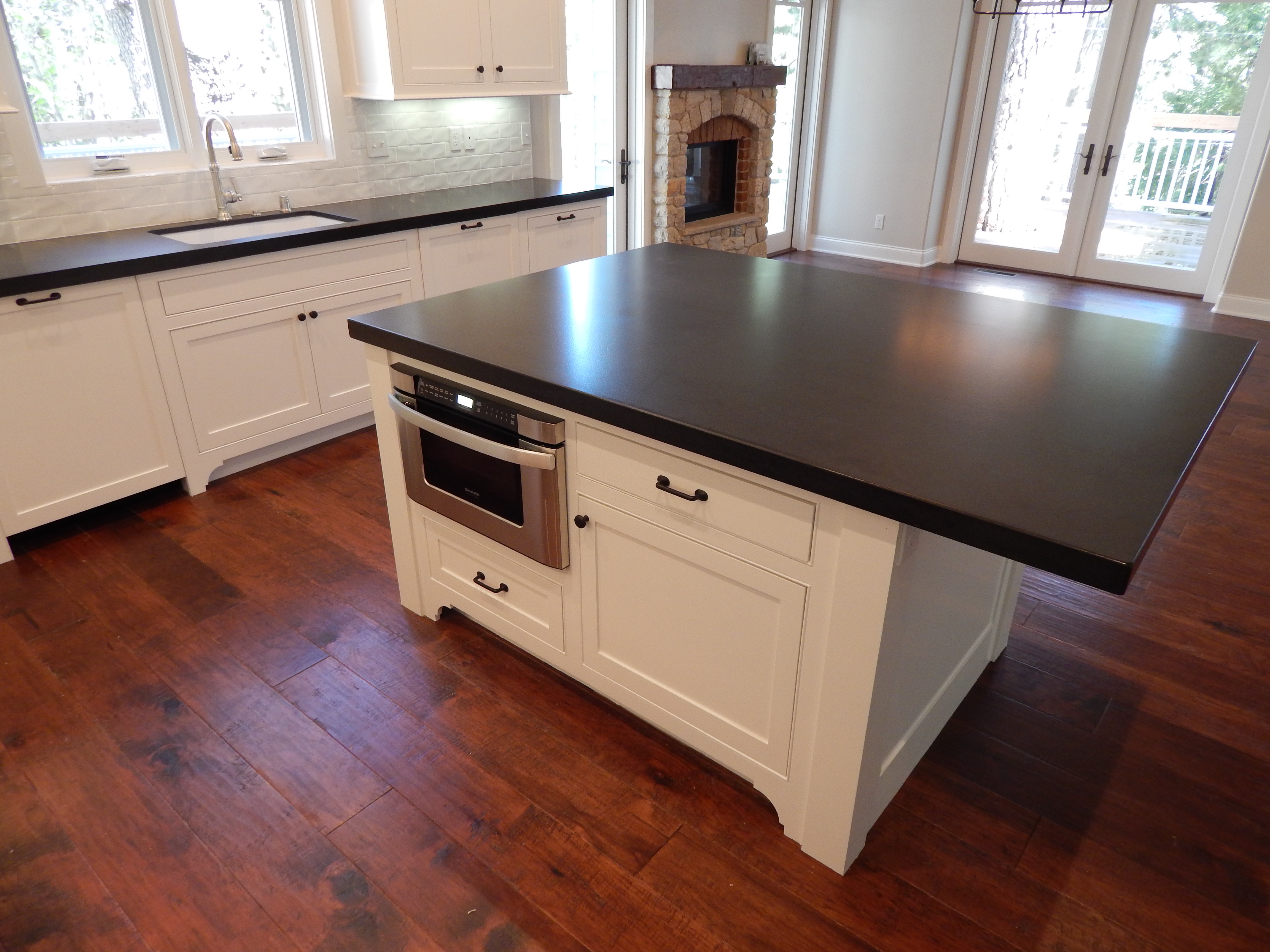 White island with dark countertop and paneled appliances
