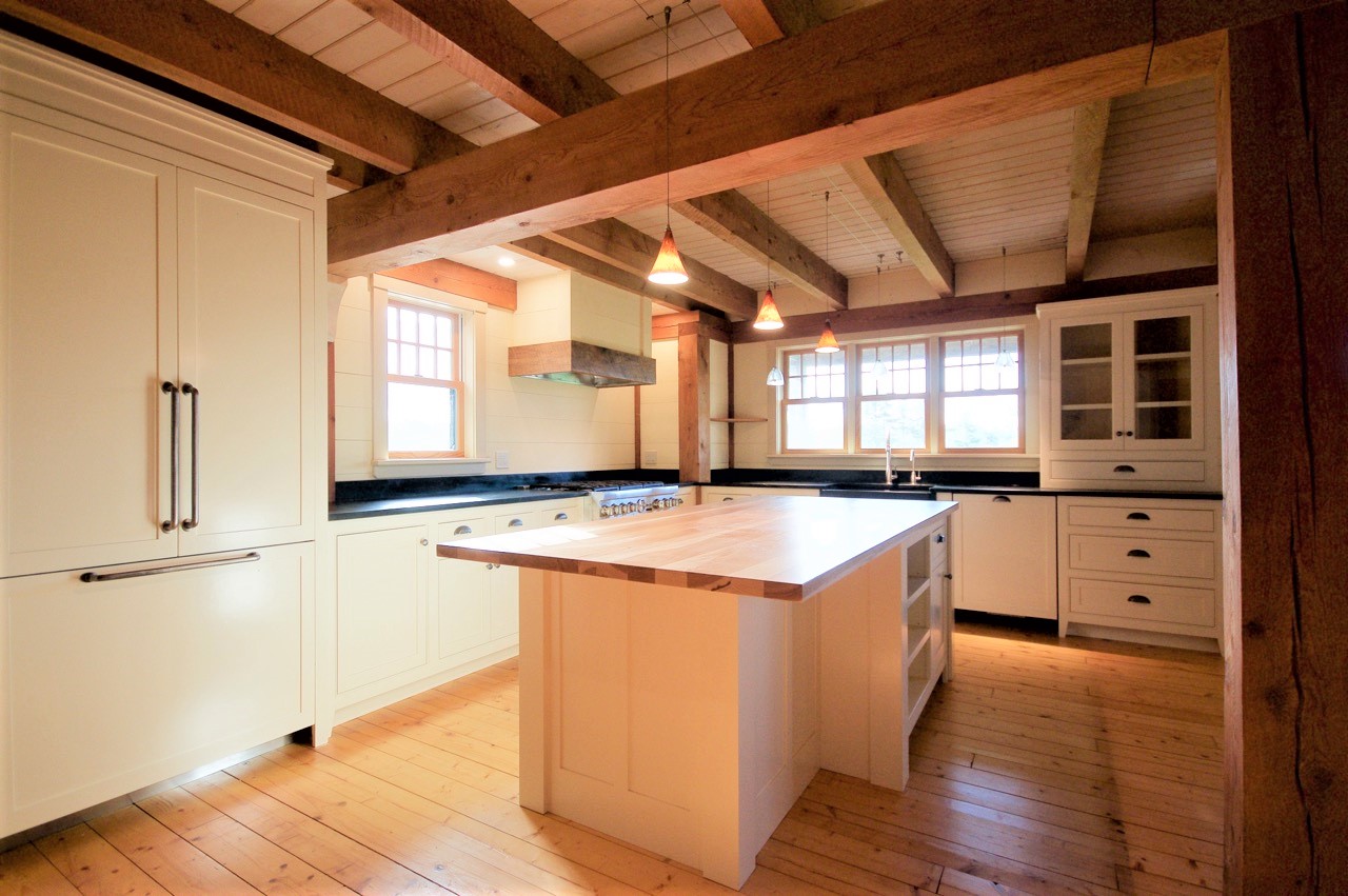 Kitchen with exposed beams and white island
