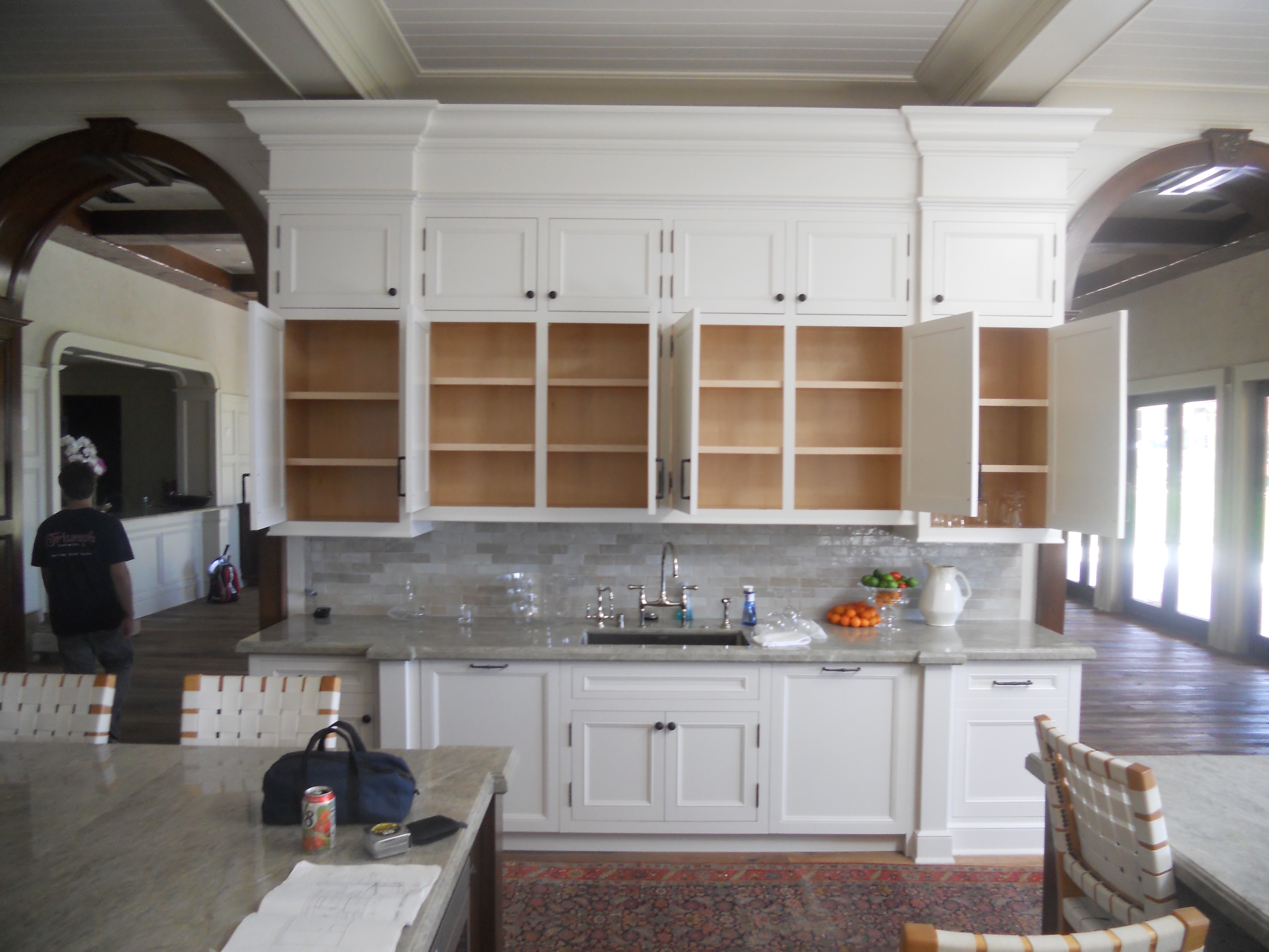 White kitchen cabinetry wall with glass-front upper cabinets