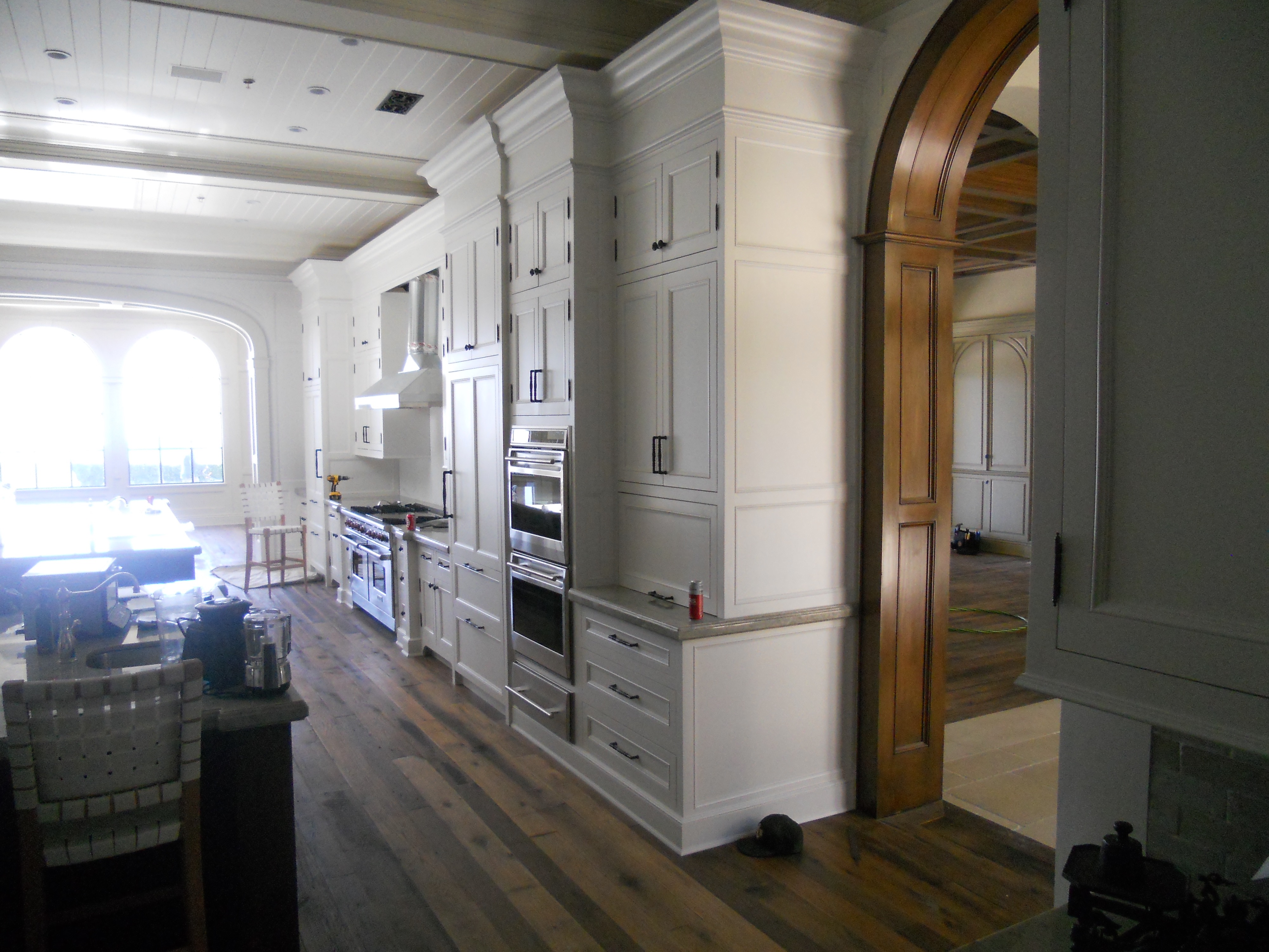 White kitchen cabinet run with arched passage