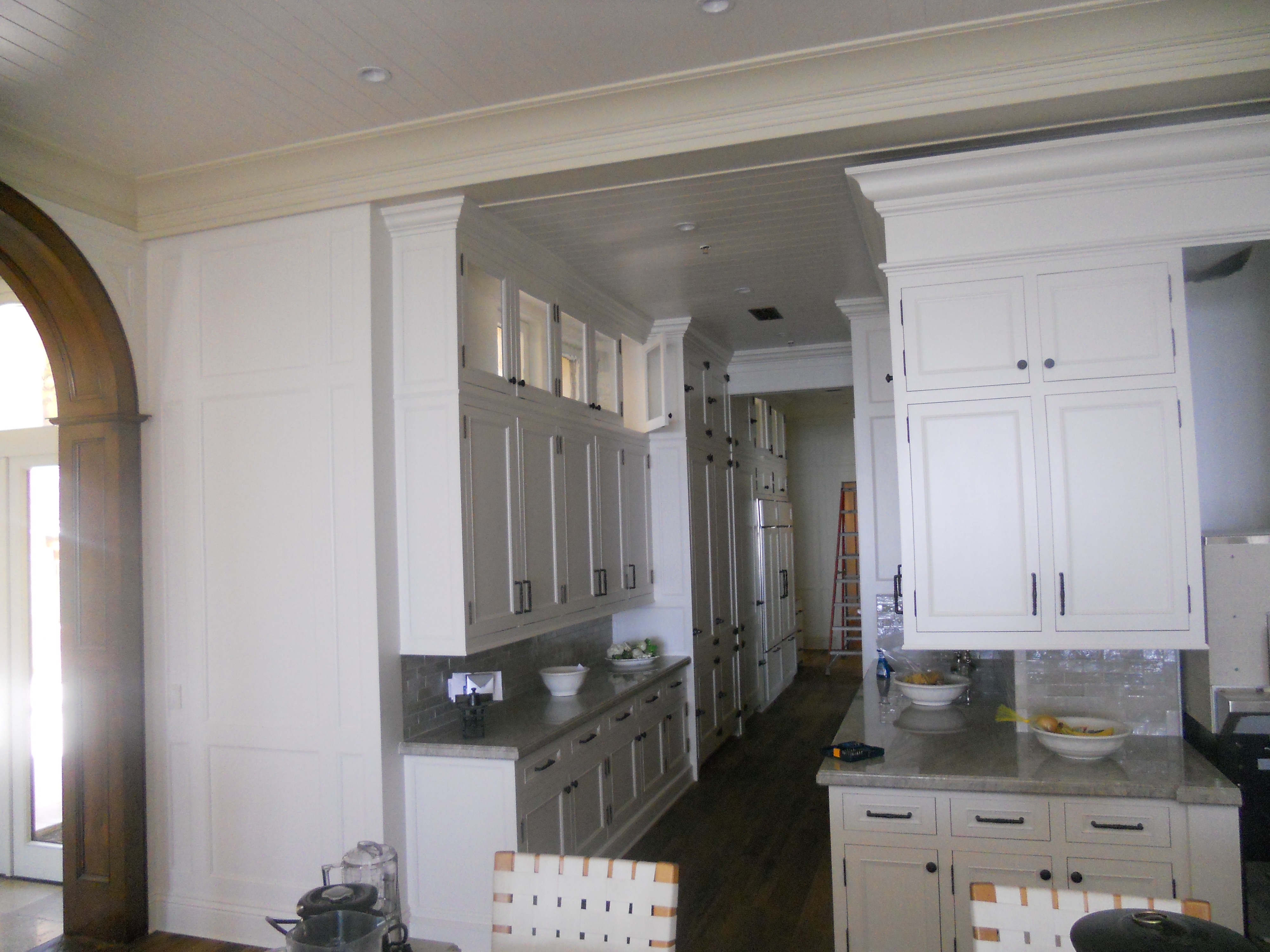 White kitchen cabinetry and arched room opening