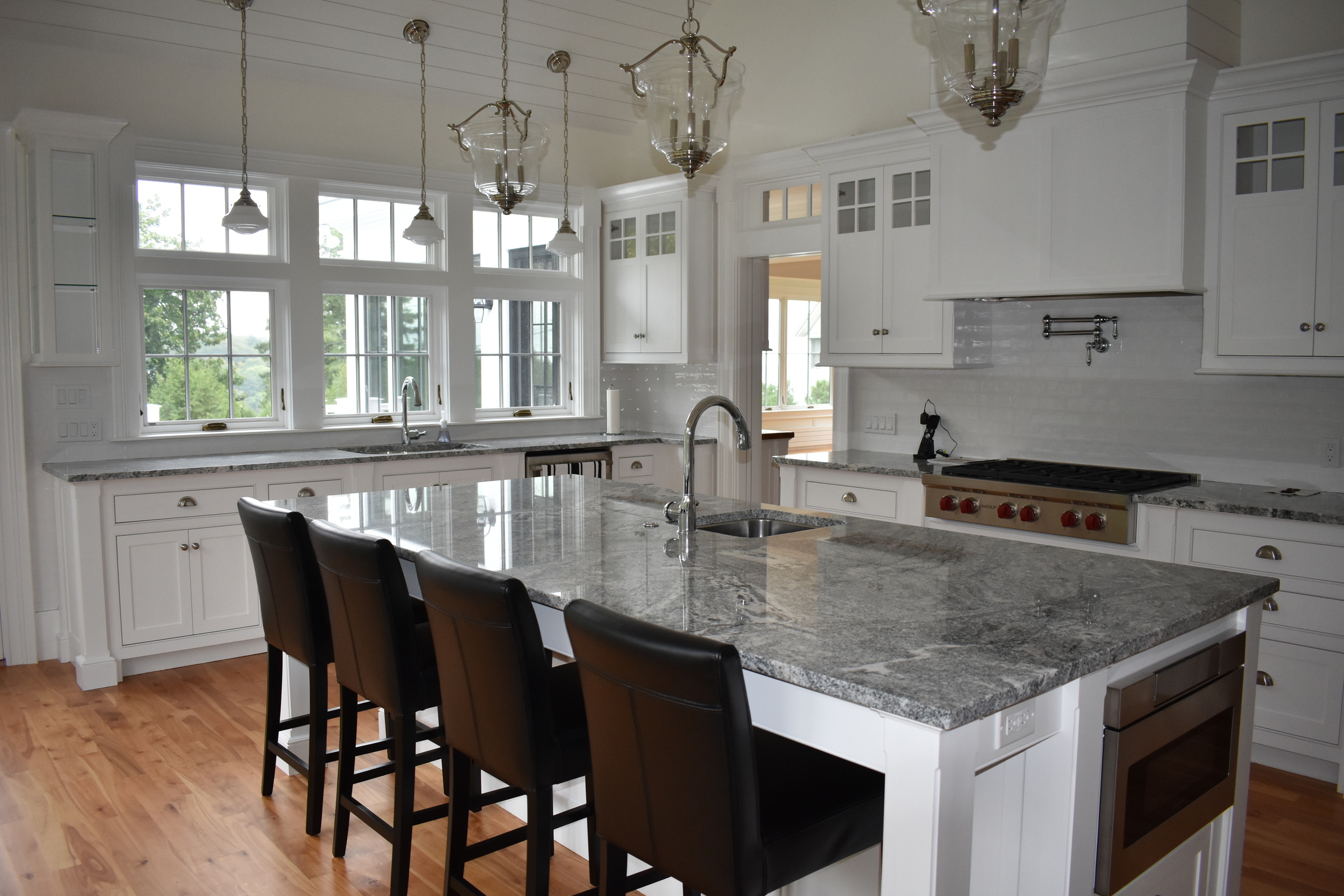 Coastal white kitchen island seating and range wall
