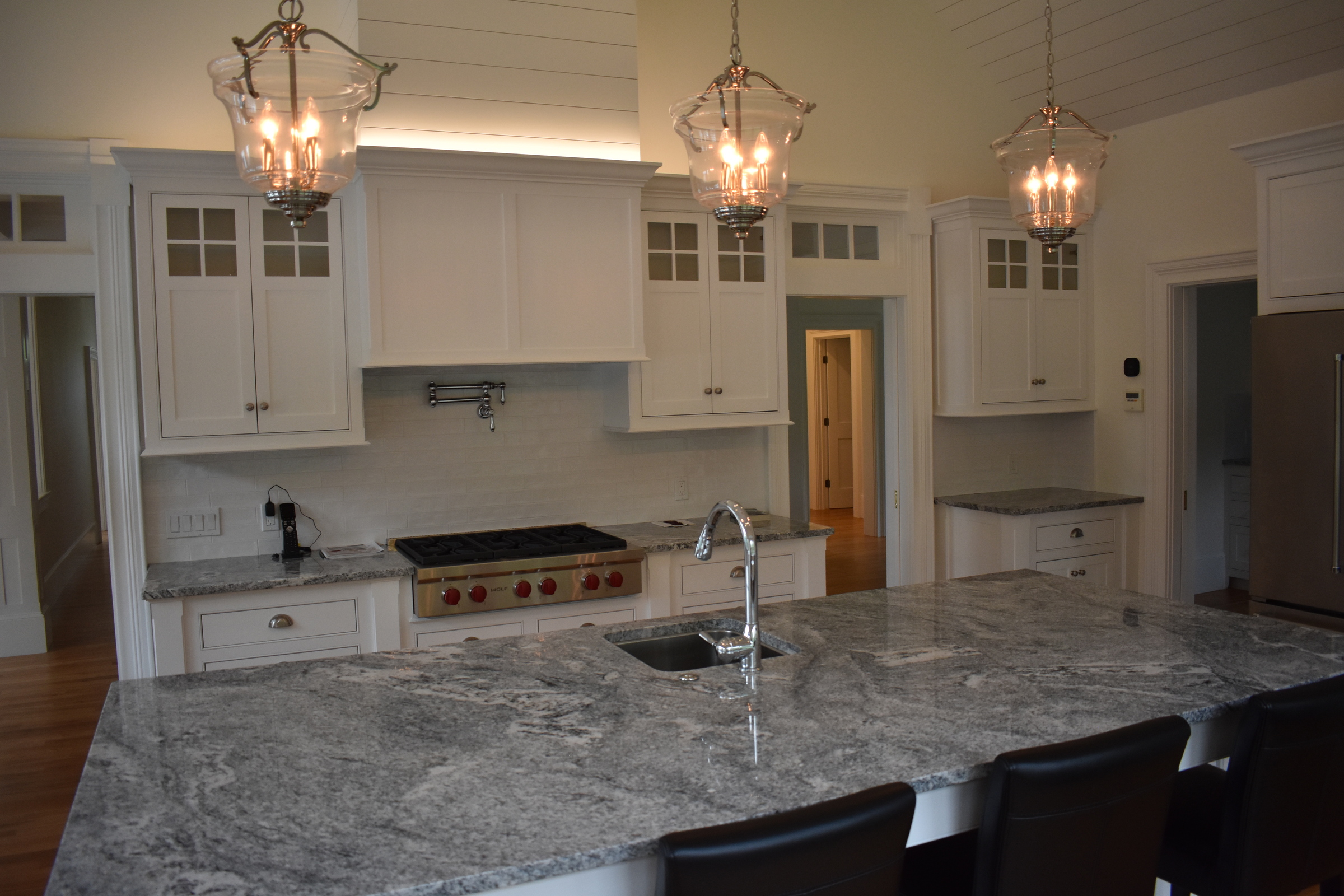 Coastal white kitchen with gray stone island countertop