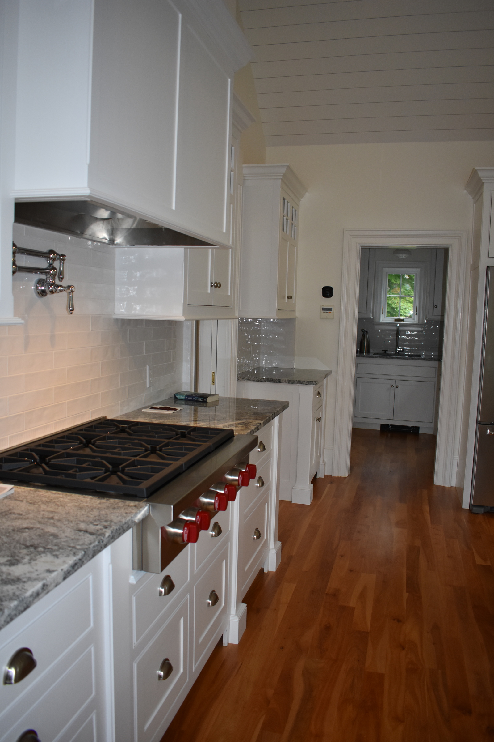 Coastal white kitchen range and custom hood detail