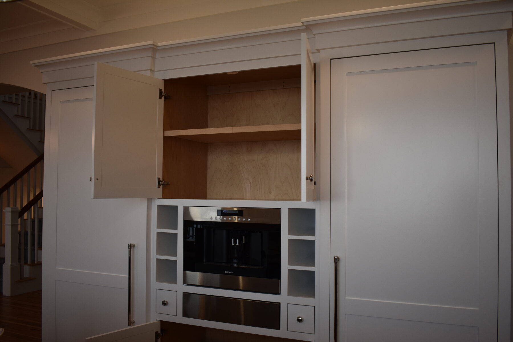 White kitchen appliance cabinet with storage doors open
