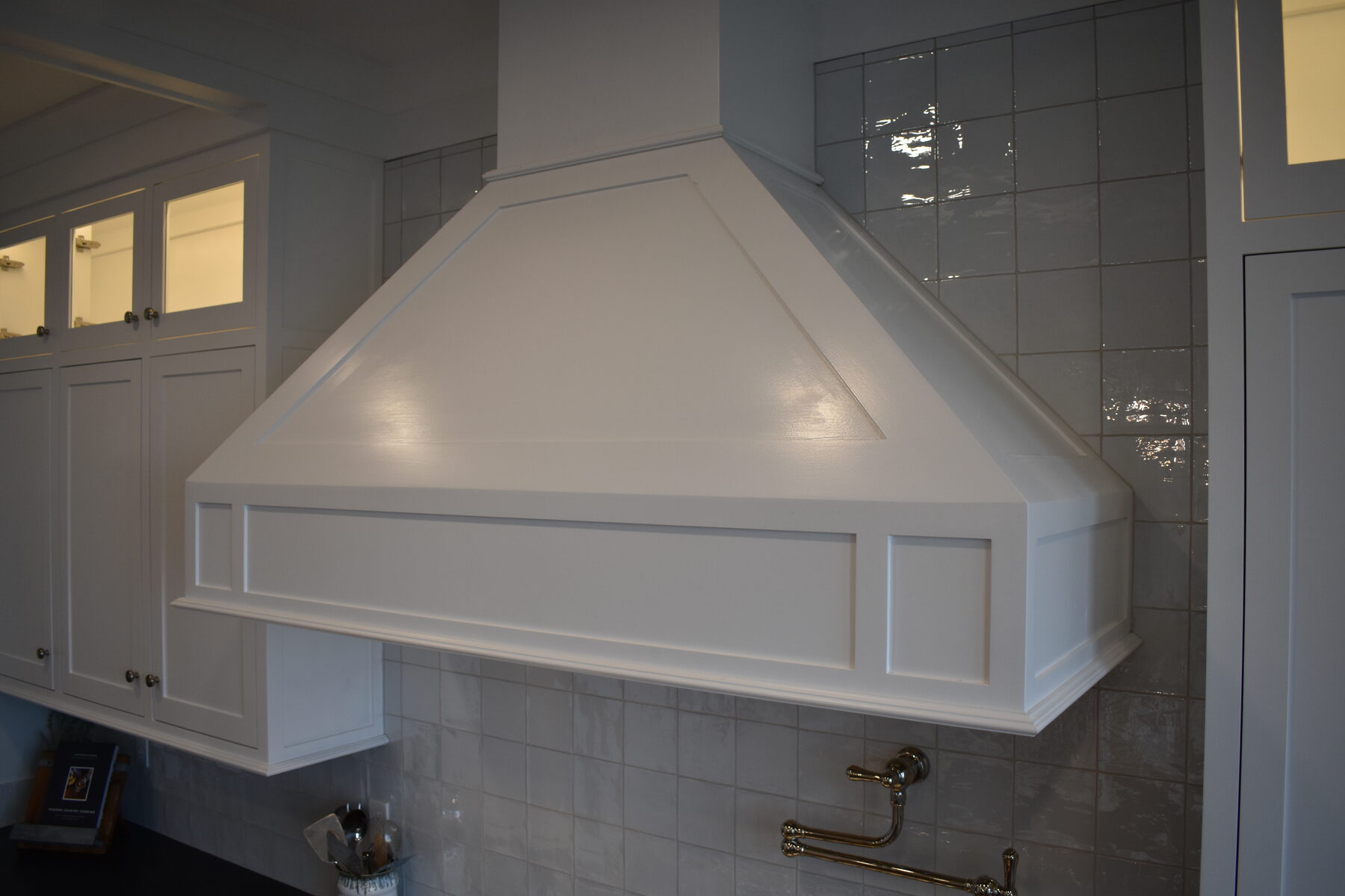 White kitchen tile backsplash and upper cabinet detail