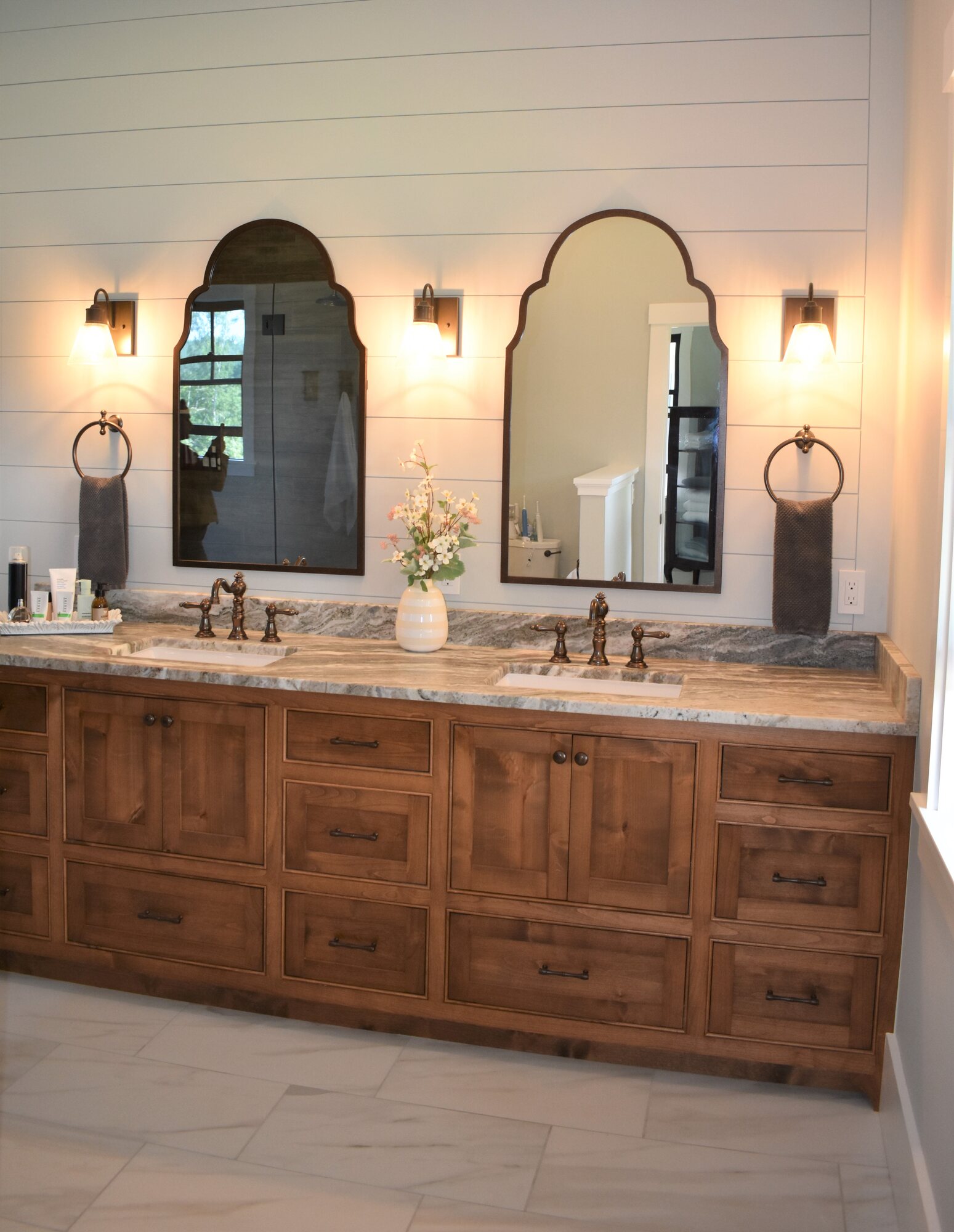 Natural wood double vanity with arched mirrors