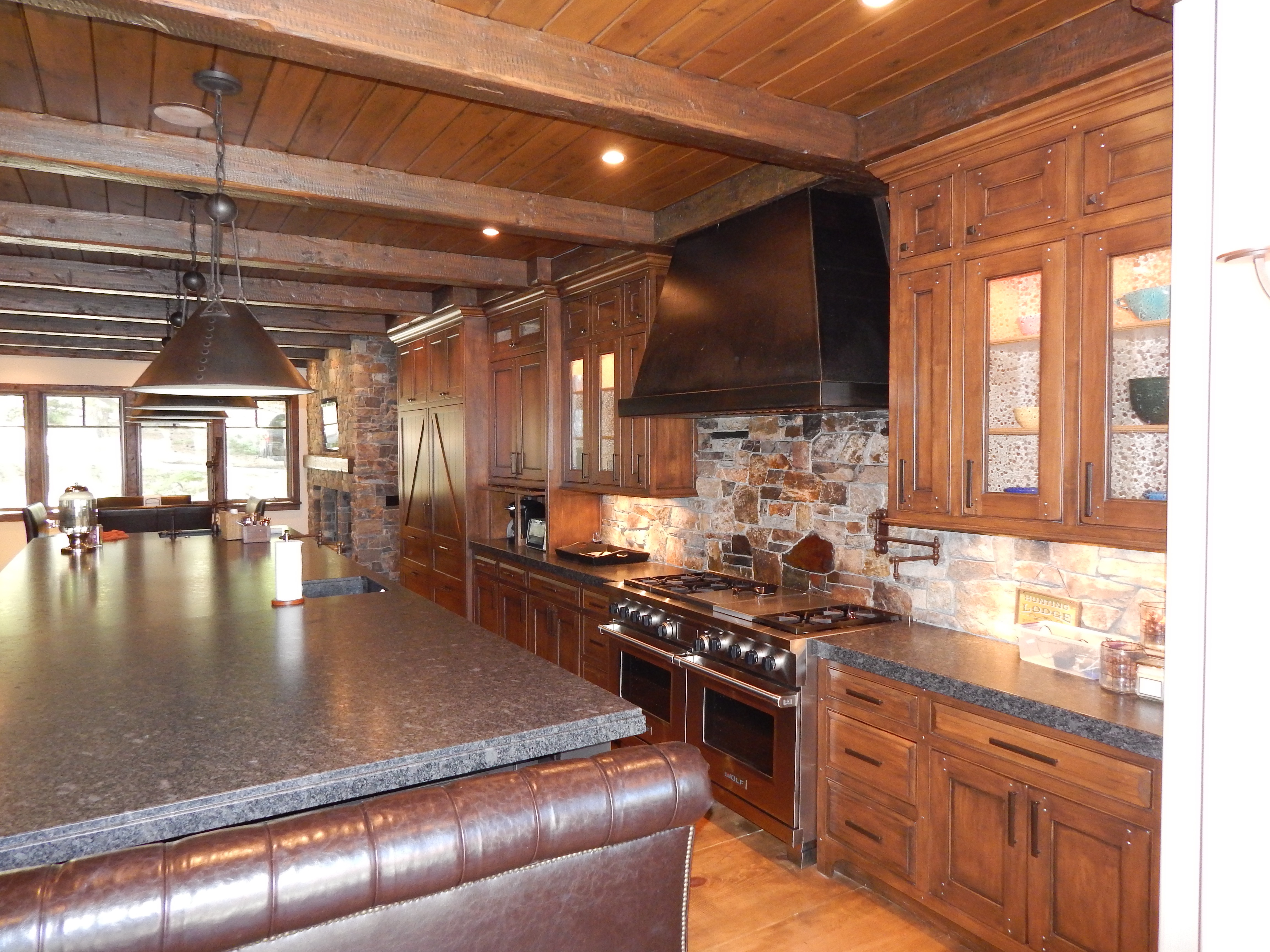 Rustic wood kitchen with dark island and stone backsplash