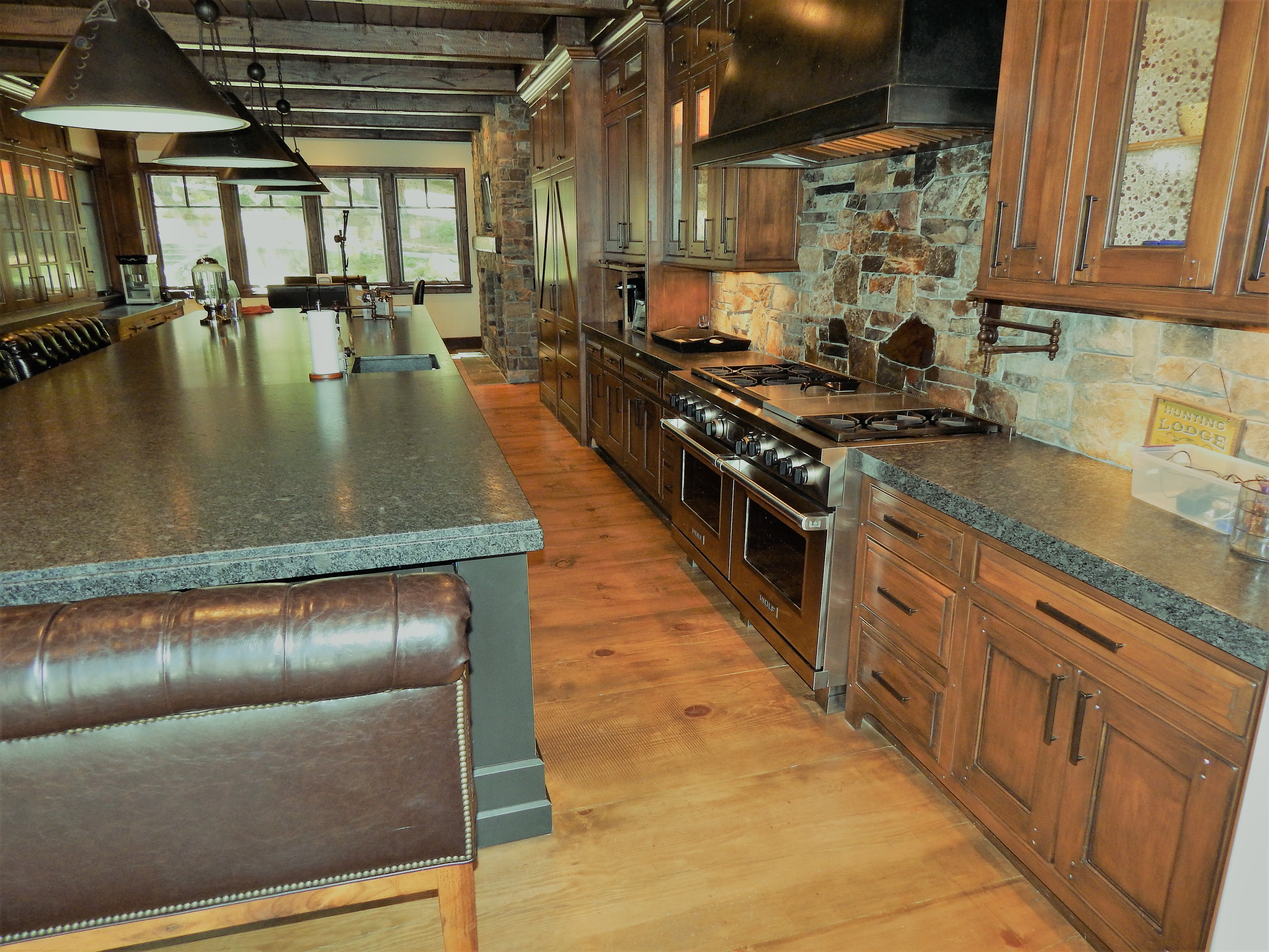 Rustic wood kitchen with dark island and range wall