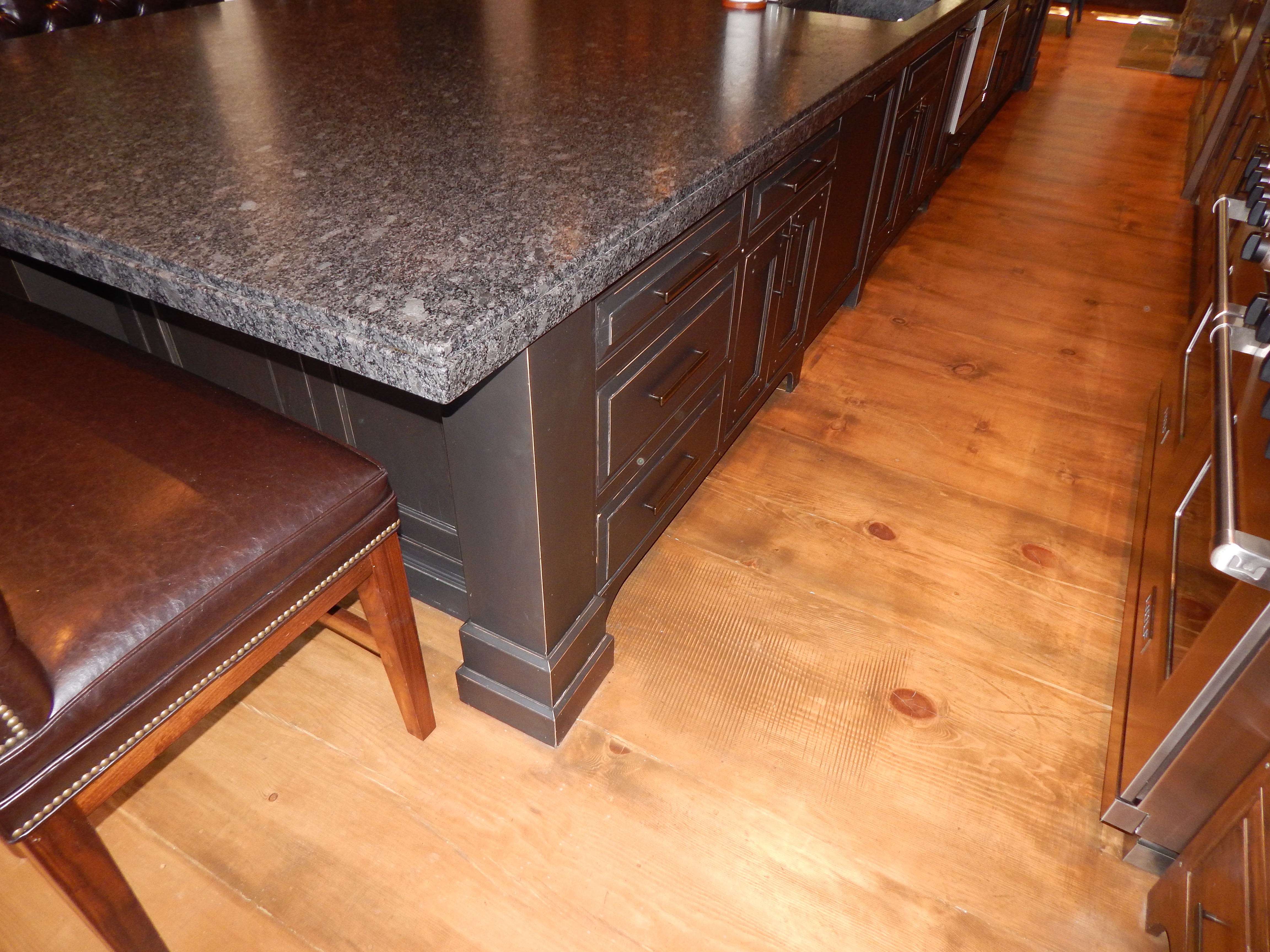 Dark island base with paneled detail and wood floor
