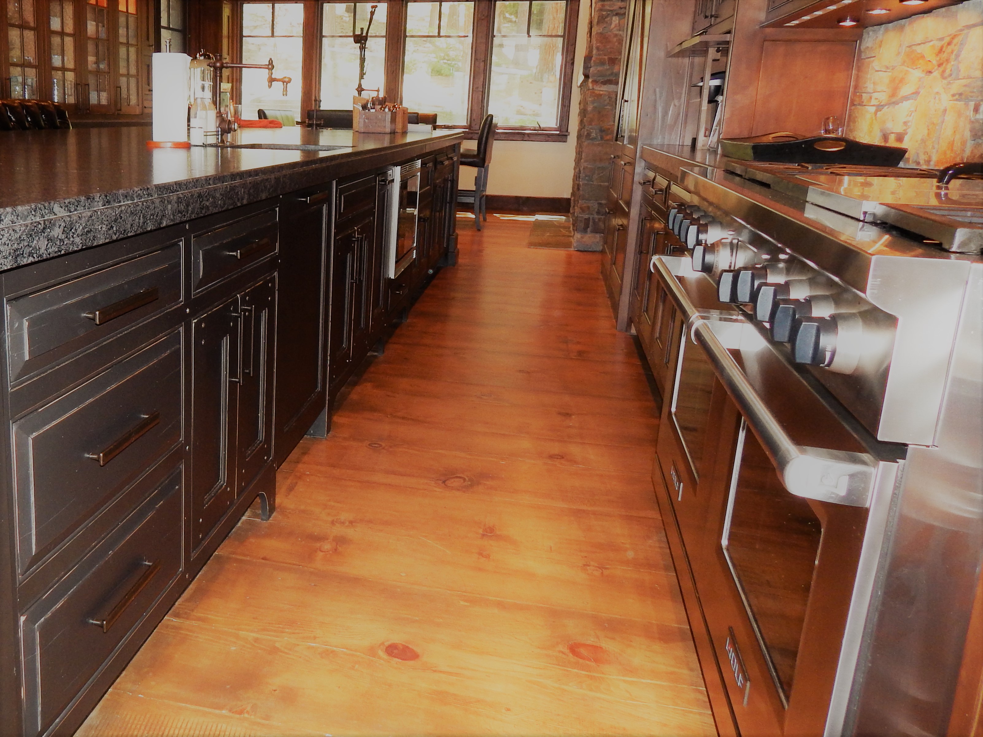 Kitchen aisle with dark lower cabinetry and range
