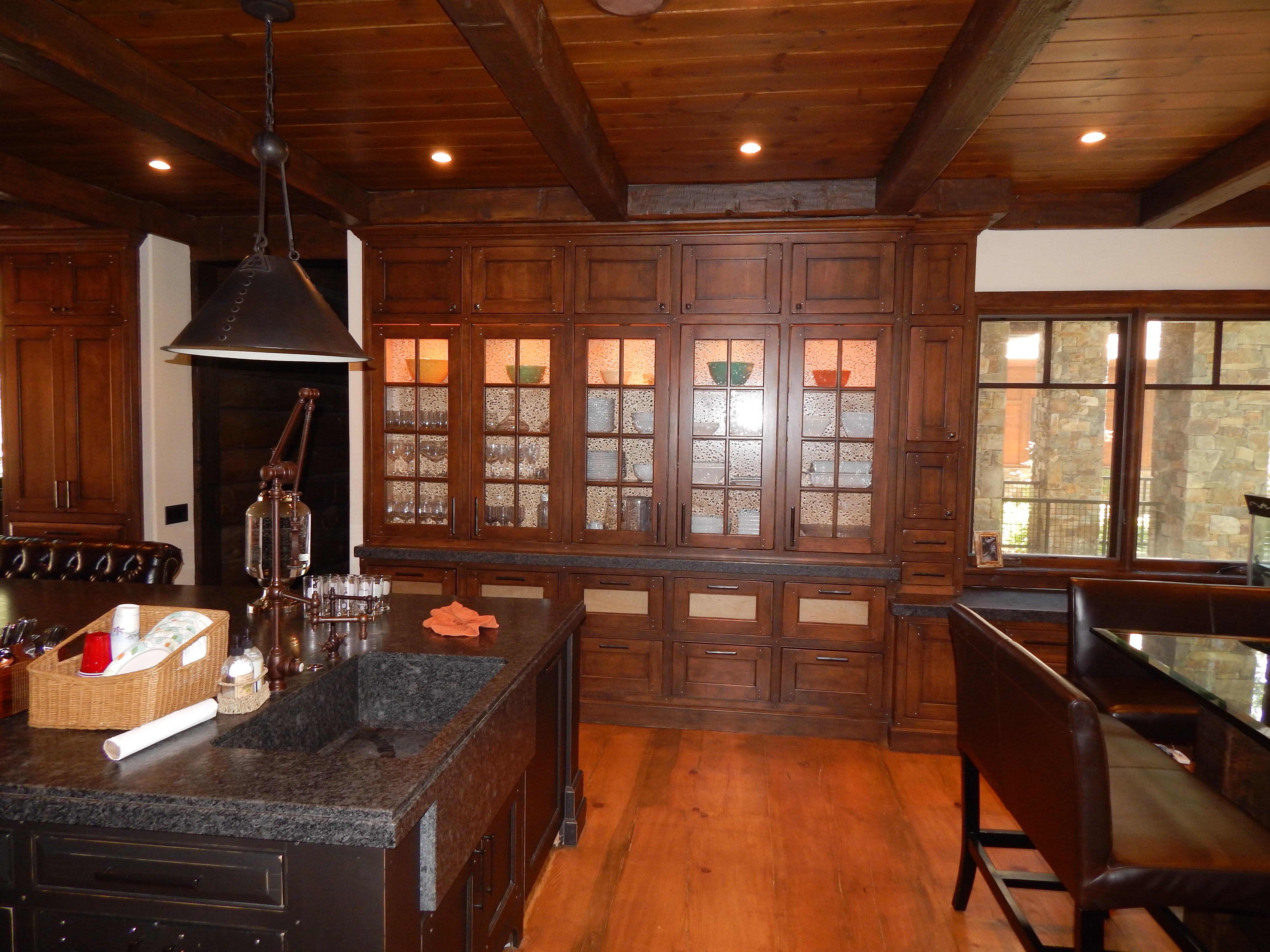 Rustic kitchen island and wall of glass-front cabinetry