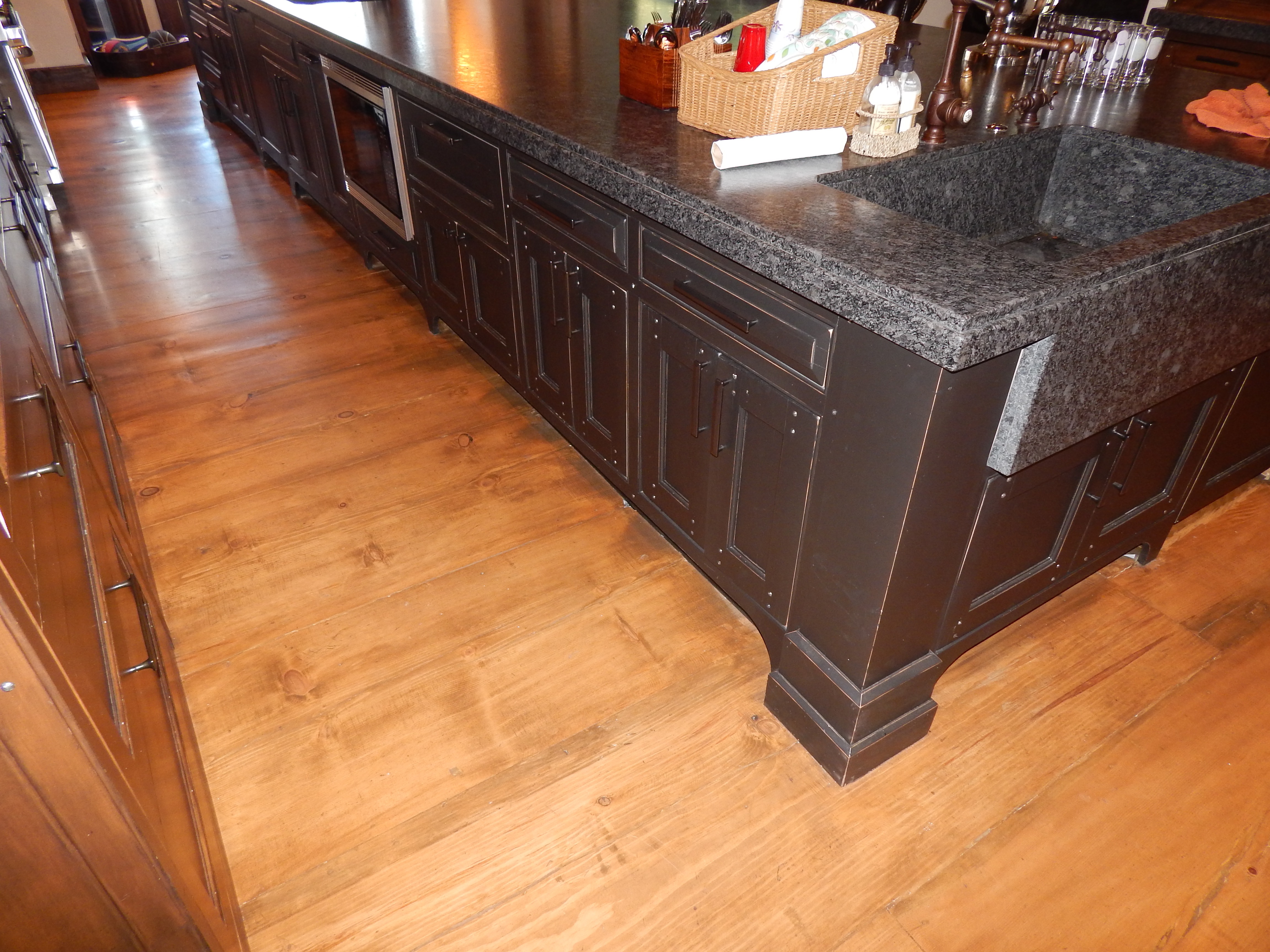Dark kitchen island with stone top and paneled end