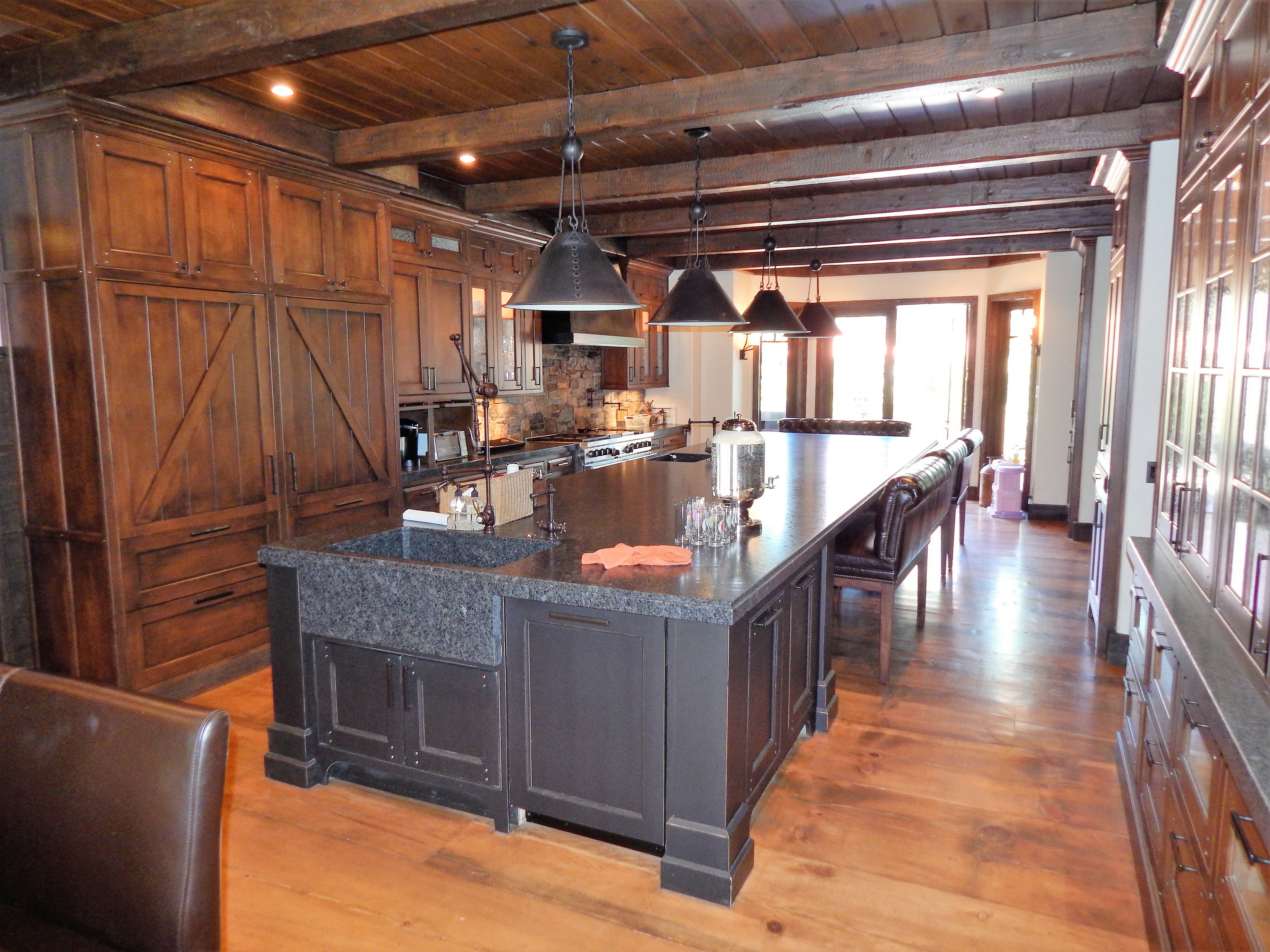 Rustic wood kitchen with dark island and pendant lighting