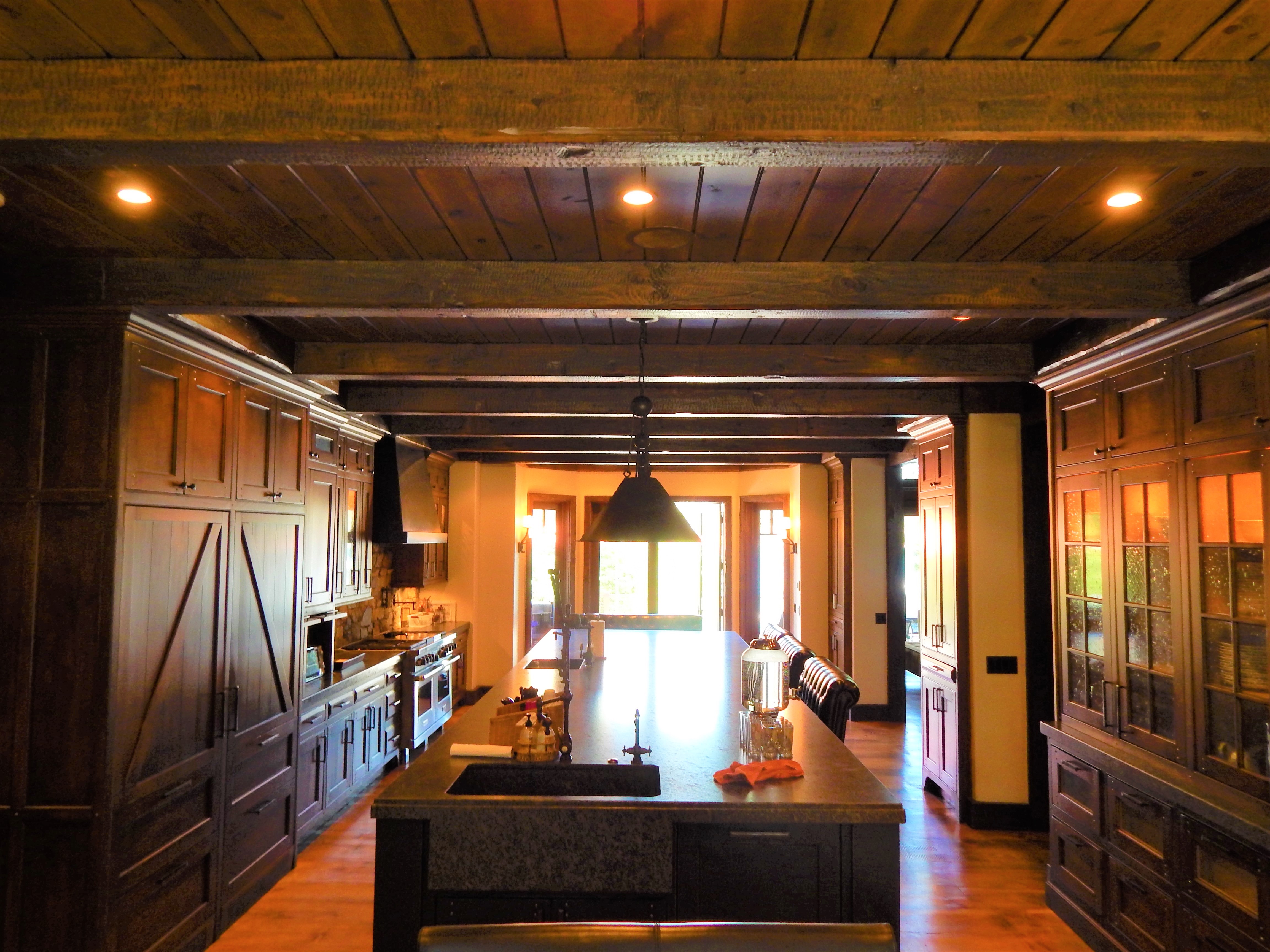 Wood-paneled kitchen corridor with dark island