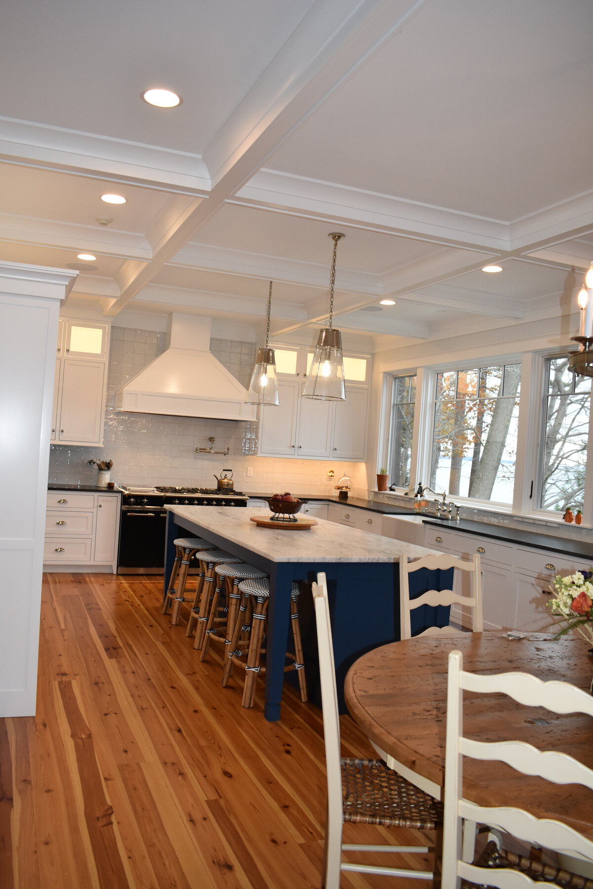 White kitchen with blue island and window wall