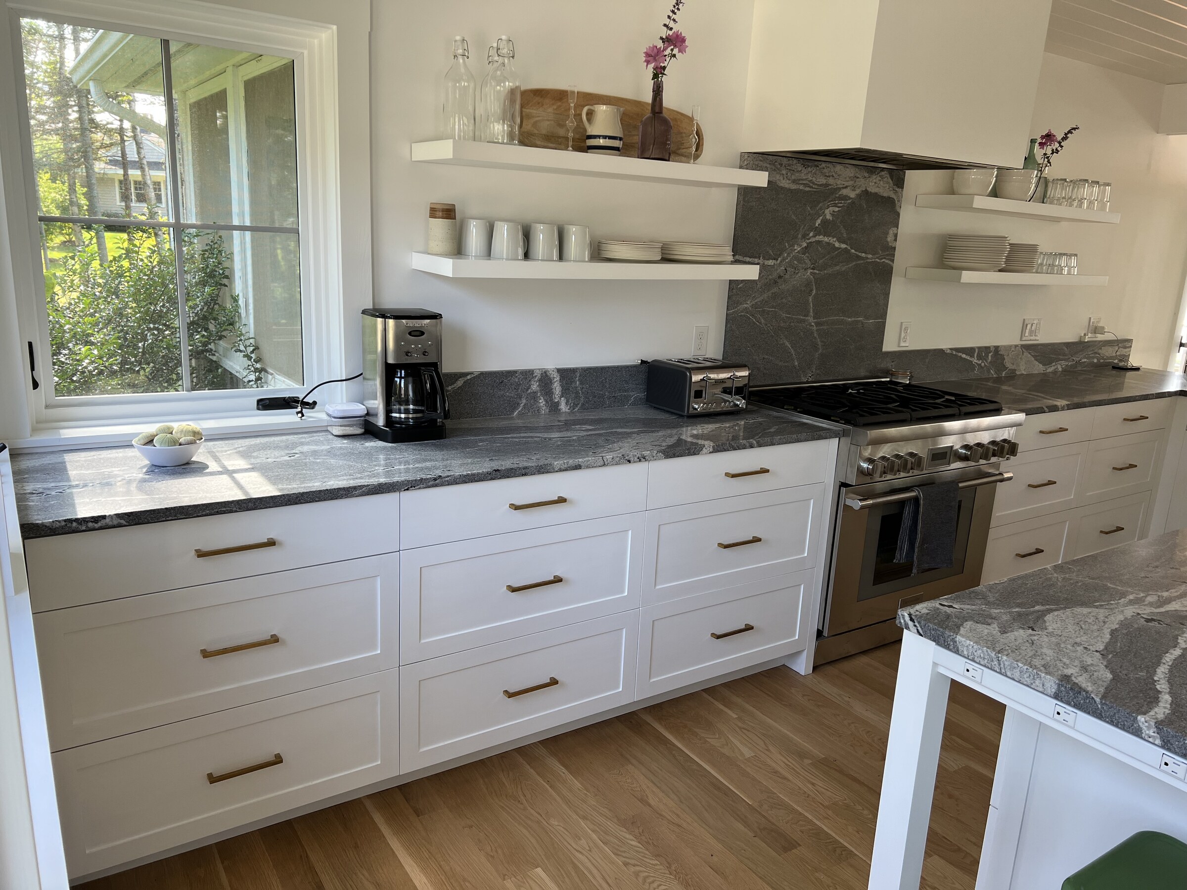 White kitchen island with gray stone countertop