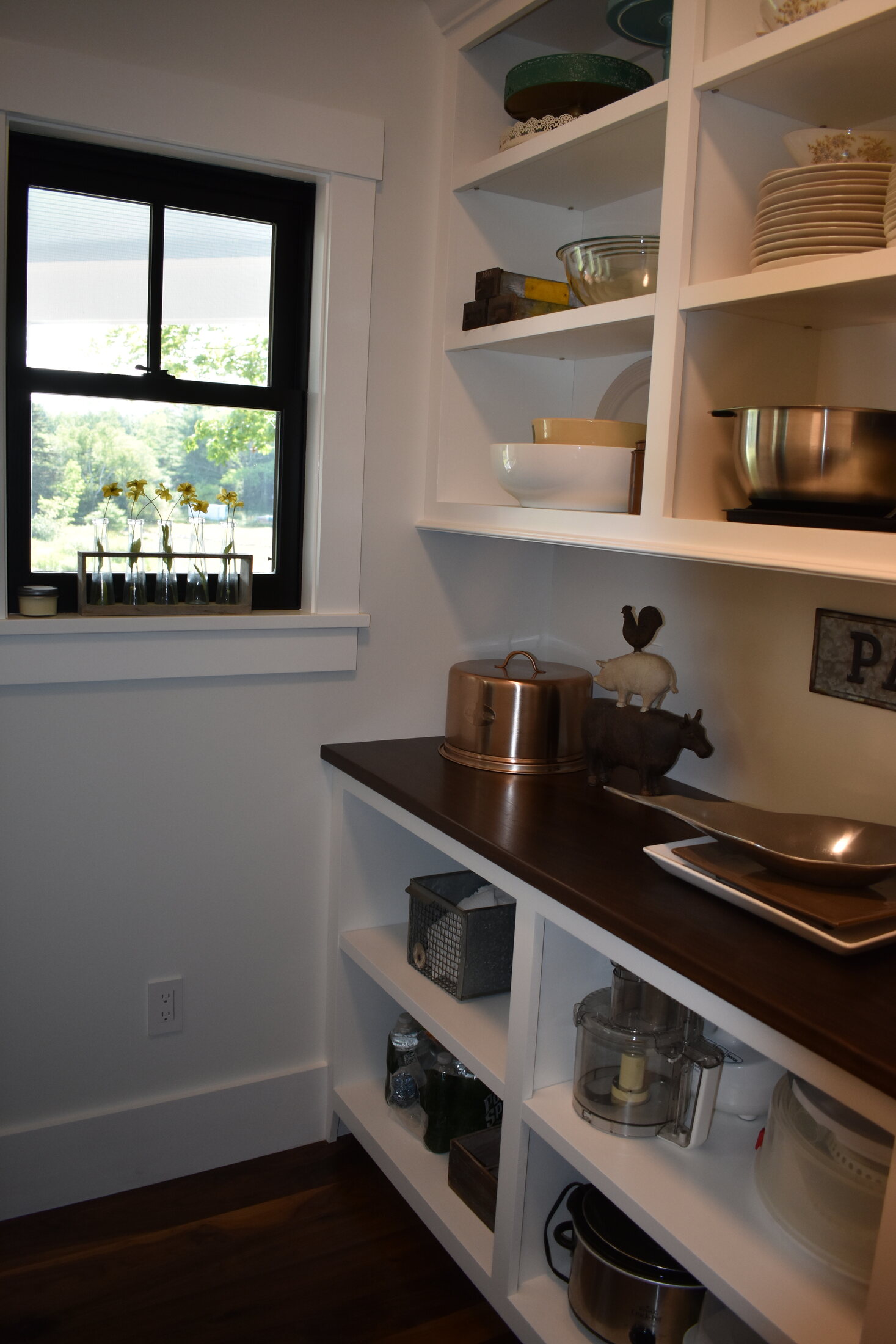 White kitchen pantry shelves beside window