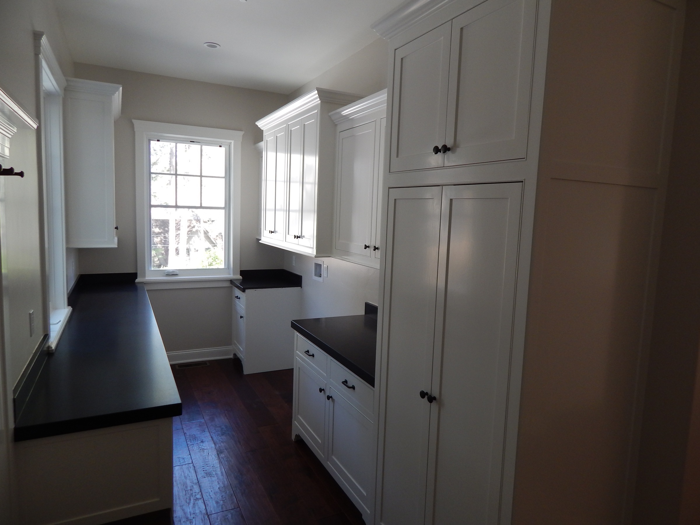 White mudroom cabinetry with tall pantry storage
